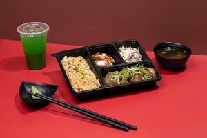 TOFU STEAK PREMIUM BENTO with mint margarita, sauce and chopsticks isolated on red background side view of japanese fast food photo