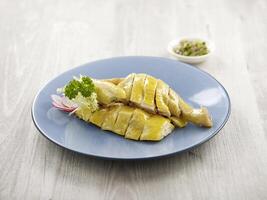 Steamed Kampong Chicken in Canton Style Served in a dish isolated on wooden board side view on grey background photo