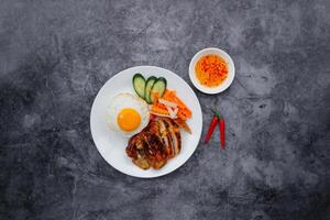 Grilled Chicken with egg, salad and chili sauce served in dish isolated on dark grey background top view of japanese food photo