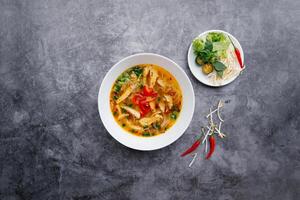 Chicken Bamboo Noodle with green leafs and lime served in bowl isolated on dark grey background top view of japanese food photo