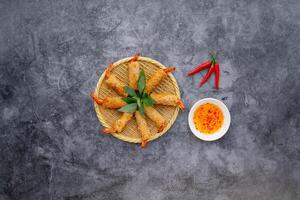 Fried Prawn Roll with sauce served in a dish isolated on dark grey background top view of japanese food photo