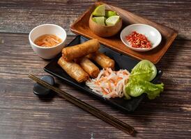 Fried spring rolls with lime and noodles served in bowl isolated on table top view of taiwan food photo