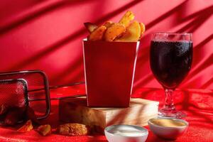 masala potato fries isolated on wooden board with mayo dip and cold drink side view photo