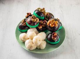Mangosteen with shell with raw fruits served in disposable glass isolated on background top view taiwan food photo