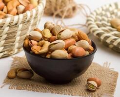 Roasted mix nuts served in a bowl isolated on napkin side view of nuts on grey background photo