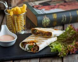 beef fajita sandwich with fries isolated on cutting board side view of fastfood on wooden background photo