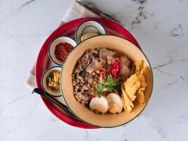 tailandés comida sukothai Cerdo tallarines en un plato aislado en estera parte superior ver en gris mármol antecedentes foto