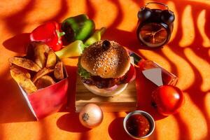 BBQ chicken cheese burger with french fries, potato and tomato slice isolated on wooden board side view on table fast food photo