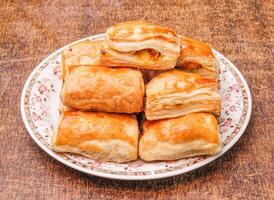 Homemade potato patties in a dish isolated on dark wooden background top view photo