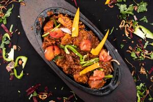 Chicken chaap or chop served in dish isolated on dark background top view of indian spices food photo