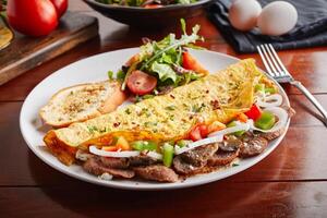 Sujuk Har omelette roll with salad served in a dish isolated on wooden background side view photo