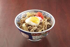 Gyu Don with egg served in a dish isolated on wooden table side view of singapore food photo