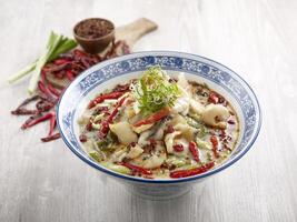 Poached Sliced Fish with Pickled Cabbage in Szechuan Style with chopsticks served in a dish isolated on mat side view on grey background photo