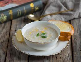 chicken corn soup with garlic bread served in a bowl isolated on wooden background side view of soup photo