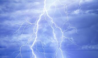 Dynamic Lightning Strikes Amidst Stormy Blue Skies. photo