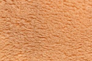 acogedor textura, suave ligero marrón osito de peluche oso tela antecedentes. foto