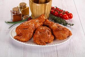 Raw turkey shoulder wing in Indian tandoori marinade photo