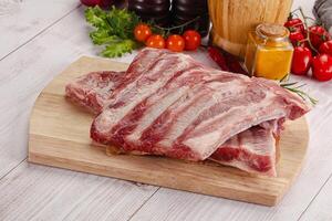 Raw pork ribs over board photo