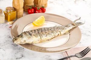 Grilled sea bass fish served lemon photo