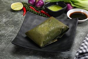 Asian cuisine - rice with filling in banana leaf photo