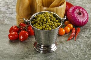 Sweet canned young green peas photo