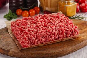 Raw minced beef meat over board photo