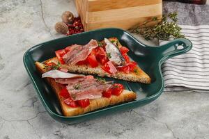 Sandwich with tomato and anchovy photo