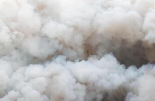 Mysterious White Smoke Swirls Amidst Billowing Black Clouds from Ignition Source. photo