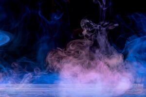 Vibrant Colored Smoke Art on Wooden Table with Dramatic Black Background. photo