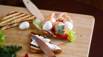 frito brindis con salmón, crema queso, ensalada, en un de madera mesa video