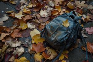 ai generado amarillo mochila en caído otoño hojas. generar ai foto