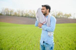 worry less ,indian farmer standing in his healthy wheat field photo