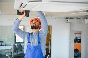 técnico Servicio comprobación y reparando aire acondicionador adentro foto