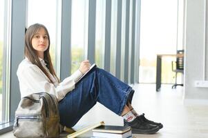 Portrait of a schoolgirl at school. She holds books in her hands. Education concept. photo