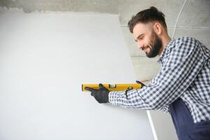 builder posing with spirit level at construction site photo