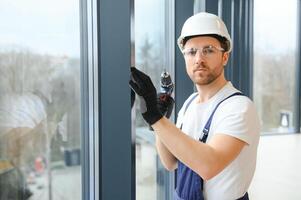 service man installing window with screwdriver photo