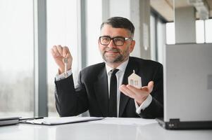 Real estate agent with house model and keys photo