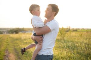 Father's day. Happy family father and toddler son playing and laughing on nature at sunset photo