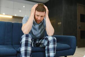 Morning of young man suffering from hangover at home photo