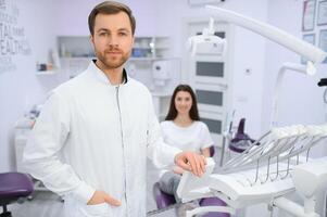 masculino dentista en un habitación con médico equipo y paciente en antecedentes. foto