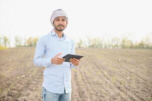 Young indian farmer at agriculture field. photo