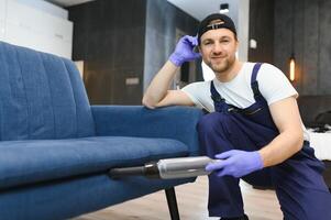 Professional janitor vacuuming armchair in room, closeup photo