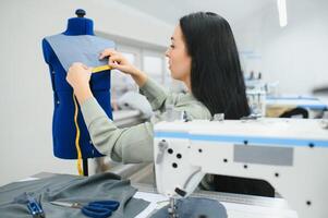 contento hembra modista trabajando con de coser máquina a textil fábrica. foto