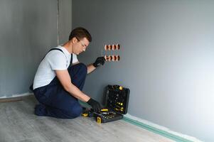 Electrician at work on switches and sockets of a residential electrical system. photo