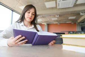 education and school concept - student girl studying and reading book at school. photo