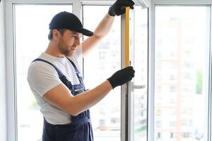 Construction worker repairing plastic window indoors, space for text. Banner design photo