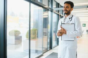 Portrait of confident Asian Indian medical doctor standing at hospital building photo