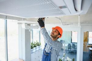 specialist cleans and repairs the wall air conditioner photo