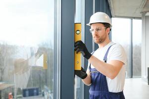 service man installing window with screwdriver photo