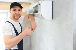 Servicio hombre es limpieza, reparar y mantenimiento de aire acondicionador. foto